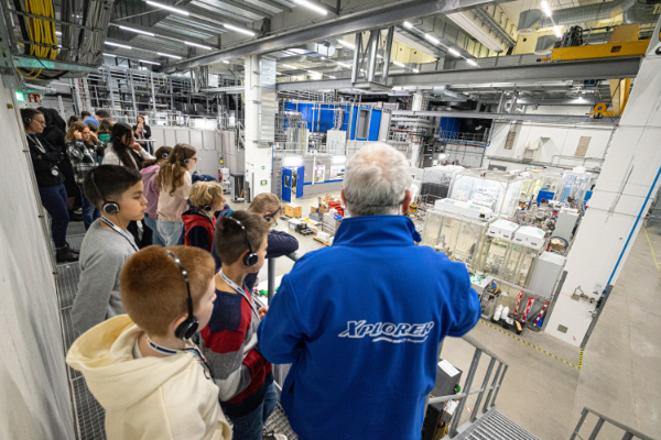 A tour guide guiding a group of young people through the experimetal hall.