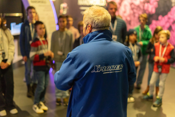 A tour guide guiding a group of young people through the Lighthouse exhibition.